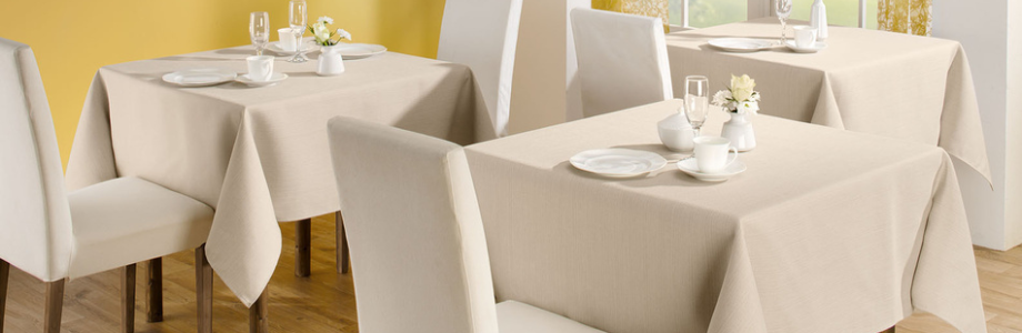Bedeckte Tische in Restaurant mit Tischdecken in Farbe Creme