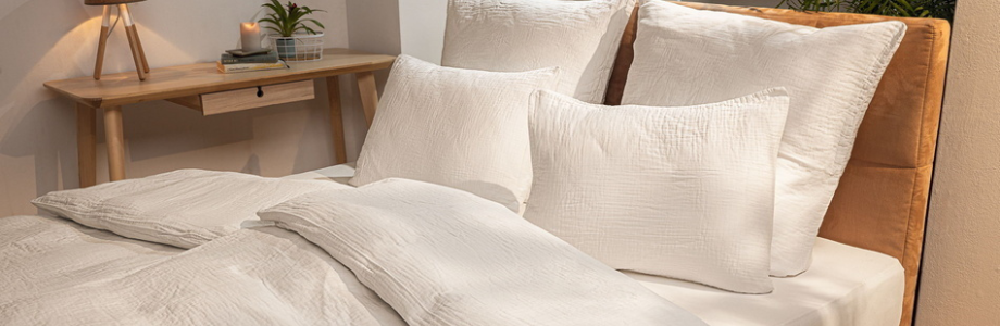 Hotelbettwäsche. Bett und auf dem Bett sind Kissen und Einziehdecke.